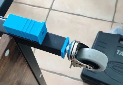 Supports de roulettes imprimés en 3D fixés sur les pieds en tube carré d'un bureau